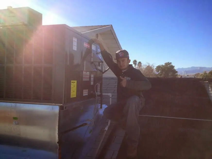 HVAC technician performing HVAC Inspection on a rooftop unit in Loganville